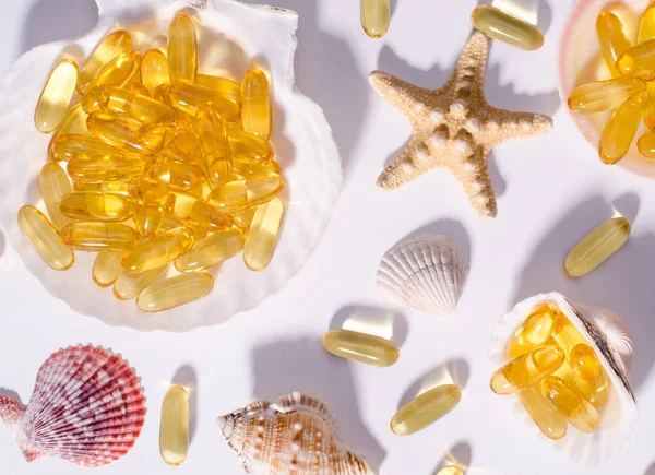 Omega-3-Kapseln und Muscheln mit langen Schatten. Foto von oben von Nahrungsergänzungsmitteln mit Öl nordischer Fische. Vitamine und Tabletten gegen Weiß. — Stockfoto