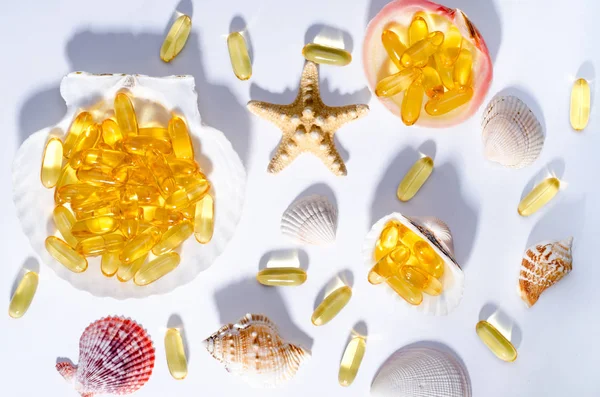 Omega 3 kapsle a mušle s dlouhými stíny. Nahoru pohled fotografie doplňku stravy olejem z nordic ryb. Vitamíny a tablety proti bílé. — Stock fotografie