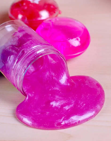 Bright pink slime spilling of from the bottle. Colle élastique avec des paillettes dans le monde entier jouet populaire pour enfants . — Photo