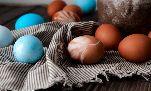 Easter background with blue Easter eggs in a basket on a wooden table. — Stock Photo, Image