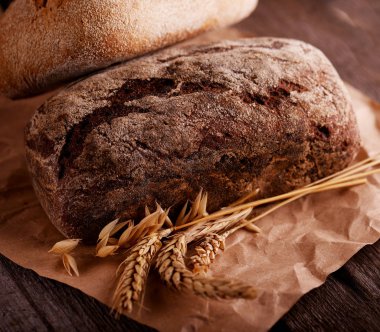 Eski ahşap bir masada taze pişmiş ekmek.