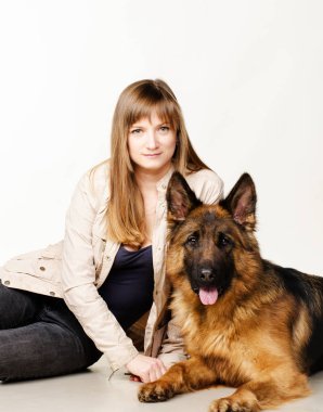 Genç kadın güzel kabarık Alman çoban köpeği beyaz arka plan karşı hugs