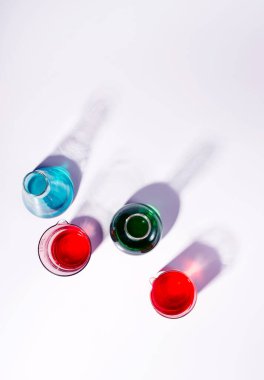 Laboratuvar şişeleri renk sıvısıyla dolu. Üst görünüm trendi natürmort.