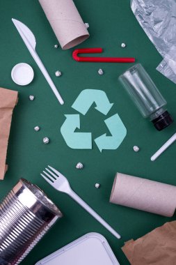 Plastik, kağıt ve polietilen atık ile geri dönüşüm düzlüğü kavramını yeniden kullan. Geri dönüşüm sembollü şablon resmi.