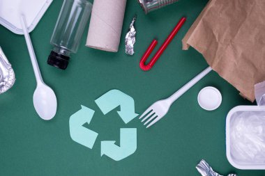 Plastik, kağıt ve polietilen atık ile geri dönüşüm düzlüğü kavramını yeniden kullan. Geri dönüşüm sembollü şablon resmi.