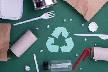Plastik, kağıt ve polietilen atık ile geri dönüşüm düzlüğü kavramını yeniden kullan. Geri dönüşüm sembollü şablon resmi.
