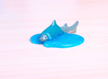 Toy Shark drowning in a blue slime. World wide trendy toy. clipart