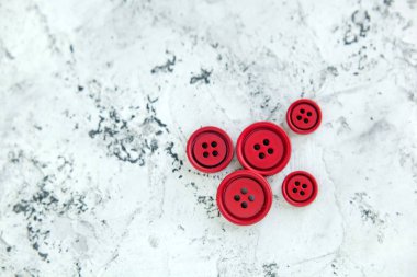 Beton arka planda kırmızı mat düğmeleri, makro bokeh. güzel nakış işi