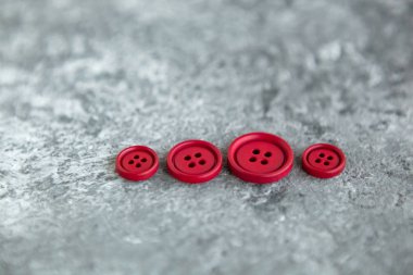 Beton arka planda kırmızı mat düğmeleri, makro bokeh. güzel nakış işi