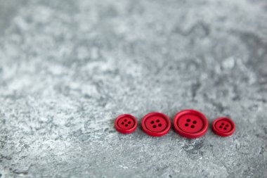 Beton arka planda kırmızı mat düğmeleri, makro bokeh. güzel nakış işi