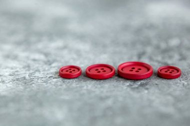 Beton arka planda kırmızı mat düğmeleri, makro bokeh. güzel nakış işi
