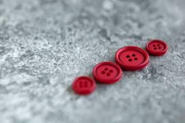 Beton arka planda kırmızı mat düğmeleri, makro bokeh. güzel nakış işi