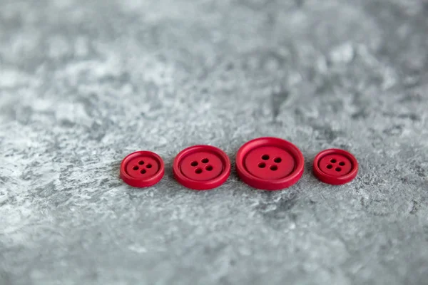 Beton arka planda kırmızı mat düğmeleri, makro bokeh. güzel nakış işi