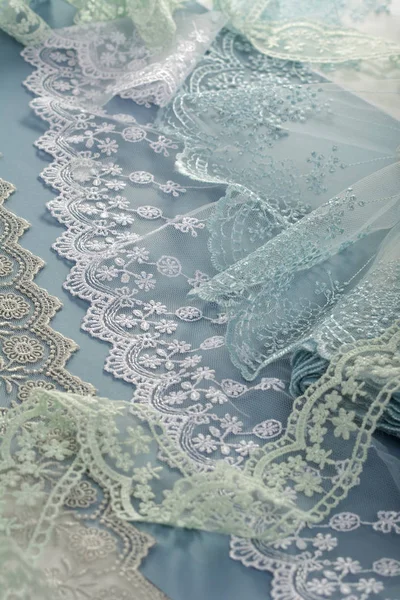 pile of gentle guipure, lace fabric on blue background