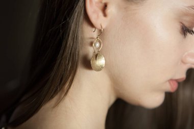Portrait of beautiful fair young woman with jewelry, one light source