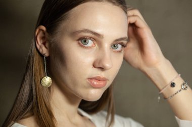 Portrait of beautiful fair young woman with jewelry, one light source
