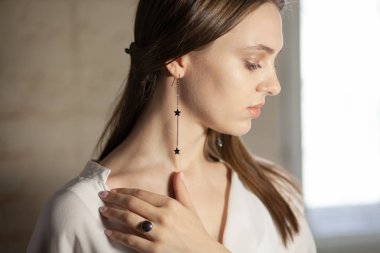 Portrait of beautiful fair young woman with jewelry, one light source
