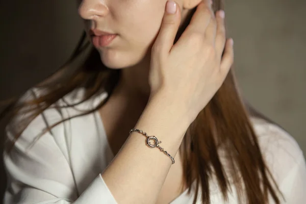 Portrait of beautiful fair young woman with jewelry, one light source
