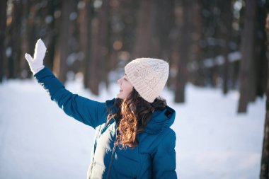 Kış ormanlarındaki alpaka yününden sıcak bir şapka takmış güzel genç kız.