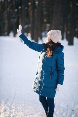 Kış ormanlarındaki alpaka yününden sıcak bir şapka takmış güzel genç kız.