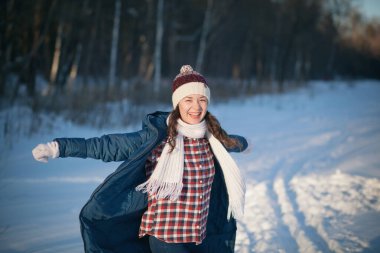 Kış ormanlarındaki alpaka yününden sıcak bir şapka takmış güzel genç kız.