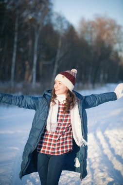 Kış ormanlarındaki alpaka yününden sıcak bir şapka takmış güzel genç kız.
