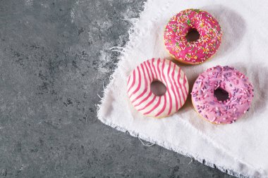 Gri beton arka planda hamur kırıntılarıyla pişirilmiş lezzetli çörekler. Yiyecek dokusu