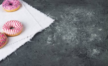 Gri beton arka planda hamur kırıntılarıyla pişirilmiş lezzetli çörekler. Yiyecek dokusu