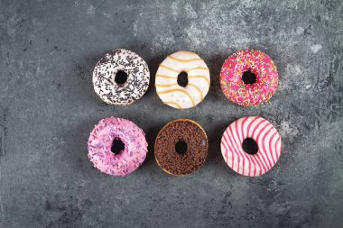 Gri beton arka planda hamur kırıntılarıyla pişirilmiş lezzetli çörekler. Yiyecek dokusu