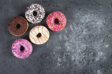 Gri beton arka planda hamur kırıntılarıyla pişirilmiş lezzetli çörekler. Yiyecek dokusu