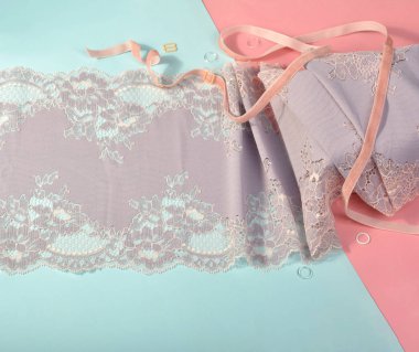 İç çamaşırı ve sütyen için narin renk bağcıkları pembe ve mavi arka planda plastik takılı. Elastik malzeme. Atıcı ve kumaş deposu için kullanılıyor.