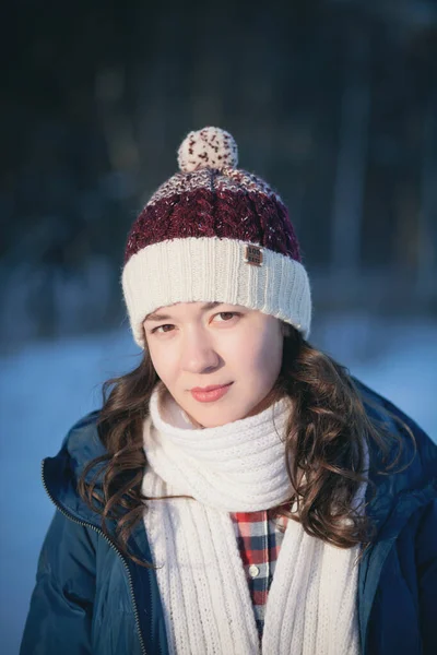 Красивая молодая девушка в теплой шапке из ваты в зимнем лесу — стоковое фото