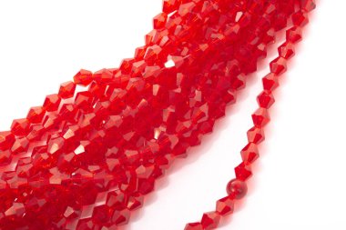 Beyaz arka planda güzel kırmızı cam kristal boncuklar. Küçük boncuklu mücevherler için kullan