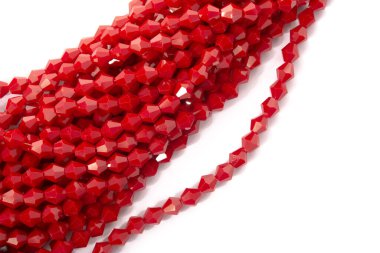 Beyaz arka planda güzel kırmızı cam kristal boncuklar. Küçük boncuklu mücevherler için kullan