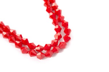 Beyaz arka planda güzel kırmızı cam kristal boncuklar. Küçük boncuklu mücevherler için kullan