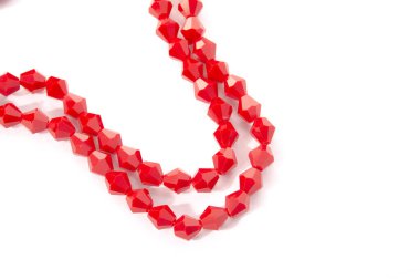 Beyaz arka planda güzel kırmızı cam kristal boncuklar. Küçük boncuklu mücevherler için kullan