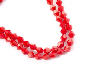 Beyaz arka planda güzel kırmızı cam kristal boncuklar. Küçük boncuklu mücevherler için kullan