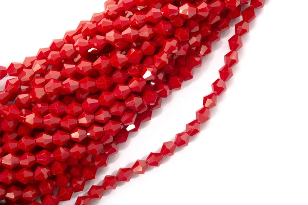 Beyaz arka planda güzel kırmızı cam kristal boncuklar. Küçük boncuklu mücevherler için kullan