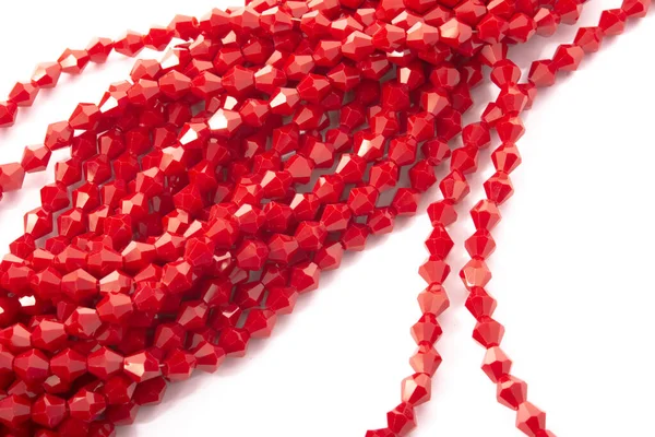 Beyaz arka planda güzel kırmızı cam kristal boncuklar. Küçük boncuklu mücevherler için kullan