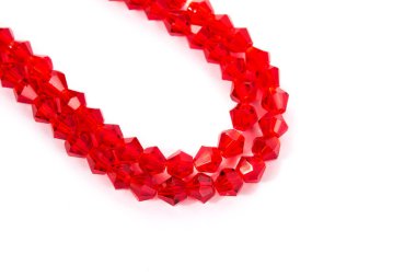 Beyaz arka planda güzel kırmızı cam kristal boncuklar. Küçük boncuklu mücevherler için kullan