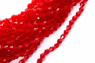 Beyaz arka planda güzel kırmızı cam kristal boncuklar. Küçük boncuklu mücevherler için kullan