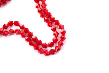 Beyaz arka planda güzel kırmızı cam kristal boncuklar. Küçük boncuklu mücevherler için kullan