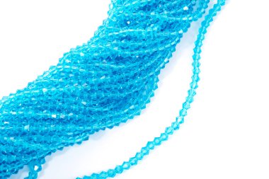 Güzel açık mavi cam parıltılı kristal boncuklar beyaz arka planda. Küçük boncuklu mücevherler için kullan