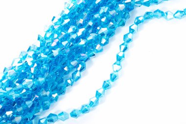 Güzel açık mavi cam parıltılı kristal boncuklar beyaz arka planda. Küçük boncuklu mücevherler için kullan