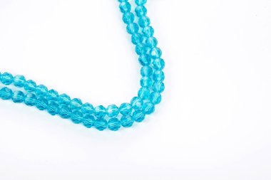 Güzel açık mavi cam parıltılı kristal boncuklar beyaz arka planda. Küçük boncuklu mücevherler için kullan