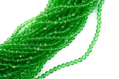 Beyaz arka planda parlak yeşil cam kristal boncuklar. Küçük boncuklu mücevherler için kullan