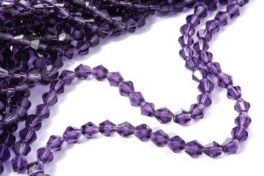 Beyaz arka planda güzel, mor cam parıltılı kristal boncuklar. Küçük boncuklu mücevherler için kullan