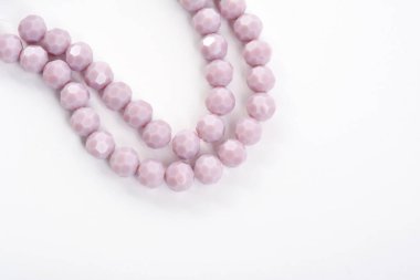 Beyaz arka planda güzel, mor cam parıltılı kristal boncuklar. Küçük boncuklu mücevherler için kullan