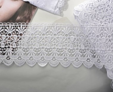 Beyaz yumuşak iplik bantları, hafif arka planda güzellik danteli kumaş. Elastik malzeme. Atıcı ve nakış dükkanı için kullanılıyor.