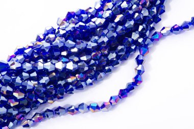 Güzel açık mavi cam parıltılı kristal boncuklar beyaz arka planda. Küçük boncuklu mücevherler için kullan